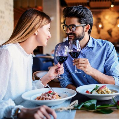 Paste and red wine. Young couple enjoying lunch in the restauran